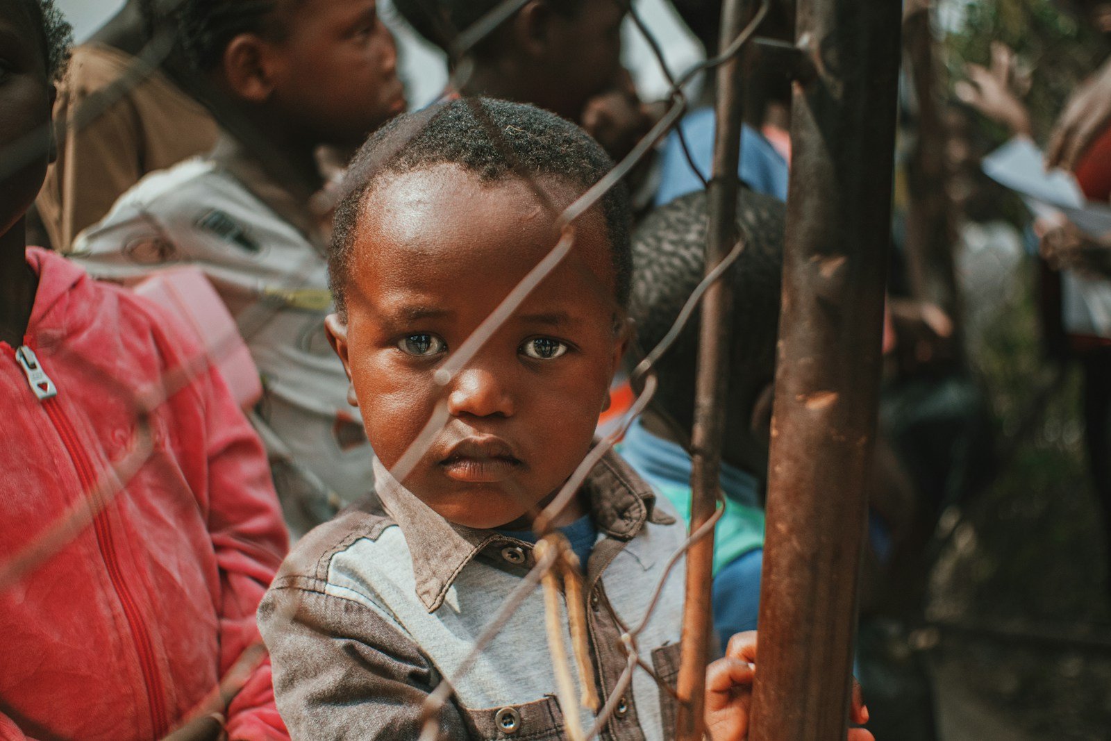 a young boy standing next to a group of people